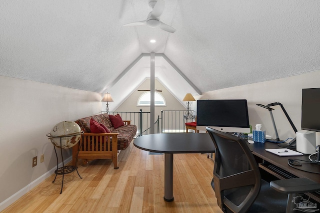 home office featuring baseboards, a ceiling fan, lofted ceiling, wood finished floors, and a textured ceiling