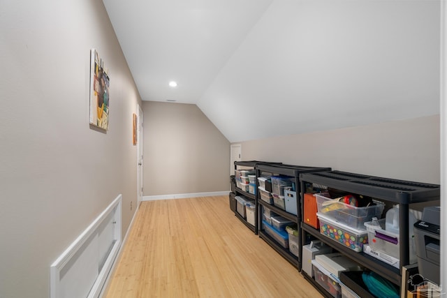 additional living space with light wood-style floors, lofted ceiling, and baseboards