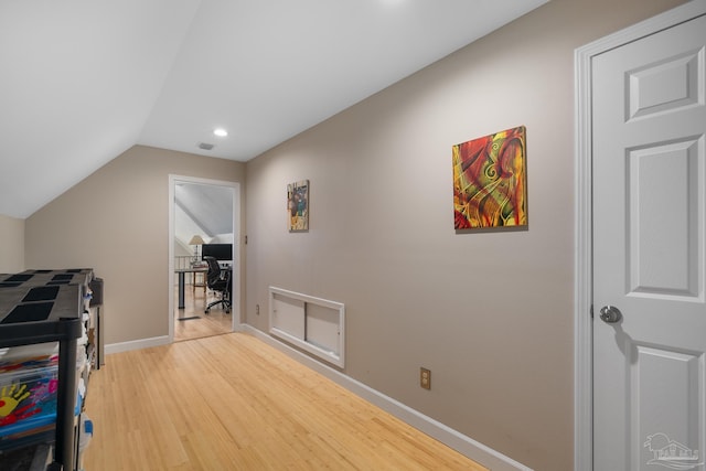 interior space with lofted ceiling, light wood-style floors, visible vents, and baseboards