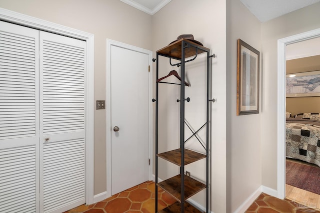 corridor with tile patterned flooring, crown molding, and baseboards