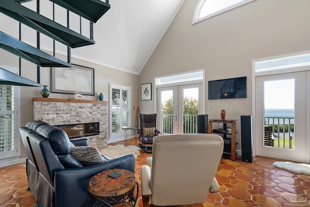 living room featuring french doors, a healthy amount of sunlight, a stone fireplace, and tile patterned floors