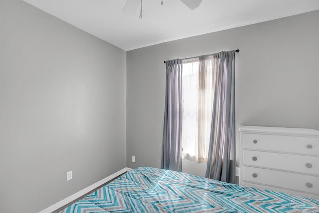 bedroom with a ceiling fan and baseboards