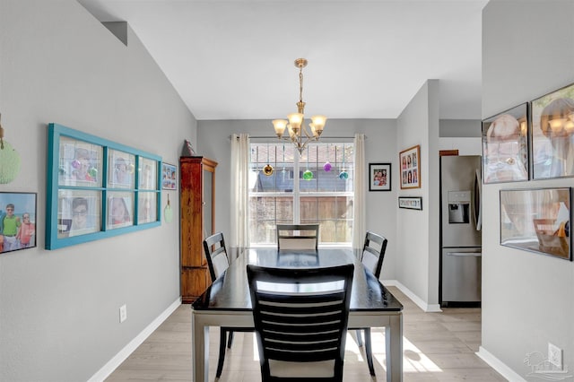 dining room featuring a chandelier, light wood-style flooring, and baseboards