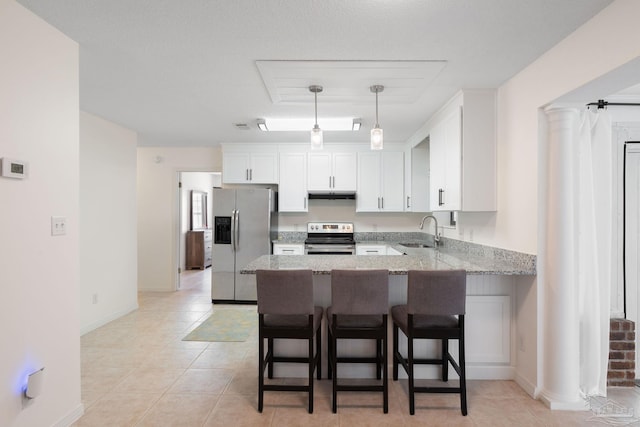 kitchen with under cabinet range hood, a peninsula, a sink, white cabinets, and appliances with stainless steel finishes