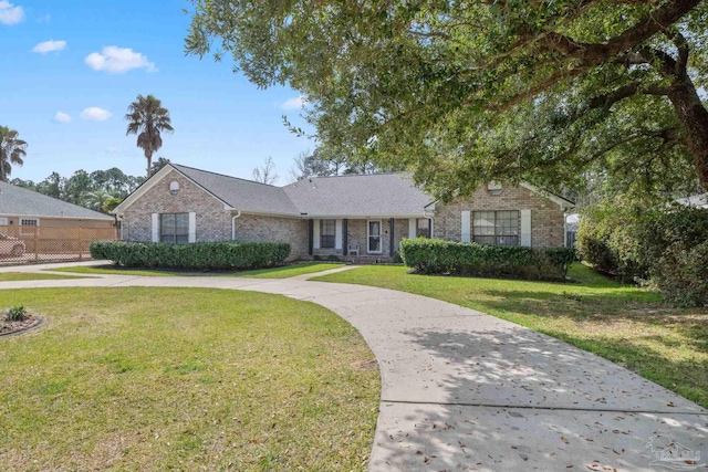 single story home with driveway, fence, a front lawn, and brick siding