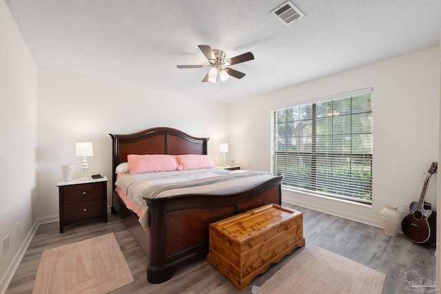 bedroom featuring a textured ceiling, wood finished floors, and visible vents