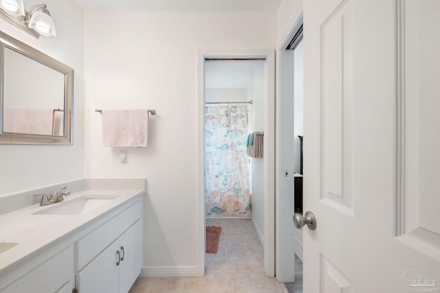 full bathroom with tile patterned flooring, a sink, baseboards, and double vanity