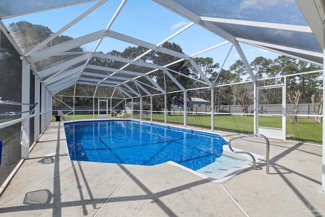 view of pool with a fenced in pool, glass enclosure, a fenced backyard, a yard, and a patio area