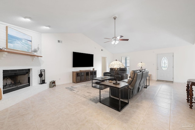 tiled living room featuring visible vents, baseboards, vaulted ceiling, a ceiling fan, and a brick fireplace