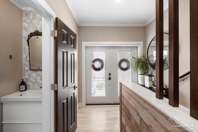 entrance foyer with french doors, light wood-style floors, and ornamental molding