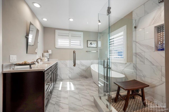 bathroom featuring a freestanding bath, vanity, recessed lighting, a stall shower, and tile walls