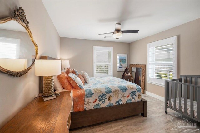 bedroom with ceiling fan, baseboards, and wood finished floors