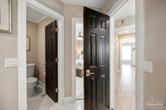 bathroom featuring tile patterned floors, baseboards, toilet, and ensuite bath