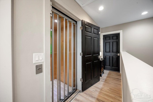 hallway with recessed lighting, light wood-type flooring, and vaulted ceiling