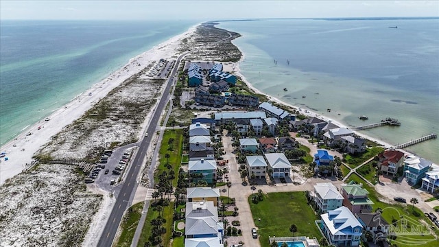 drone / aerial view featuring a view of the beach, a water view, and a residential view