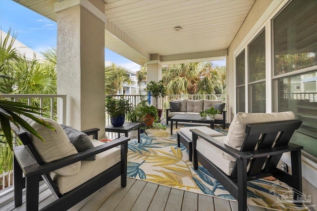 wooden terrace with an outdoor living space