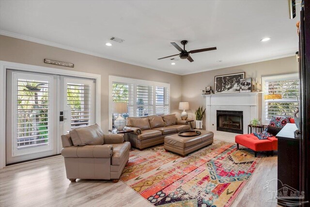 living room with visible vents, plenty of natural light, and ornamental molding