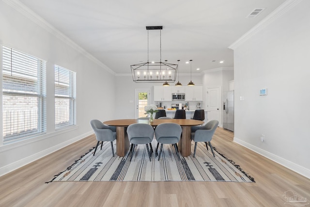 dining area with light wood-style floors, baseboards, and visible vents