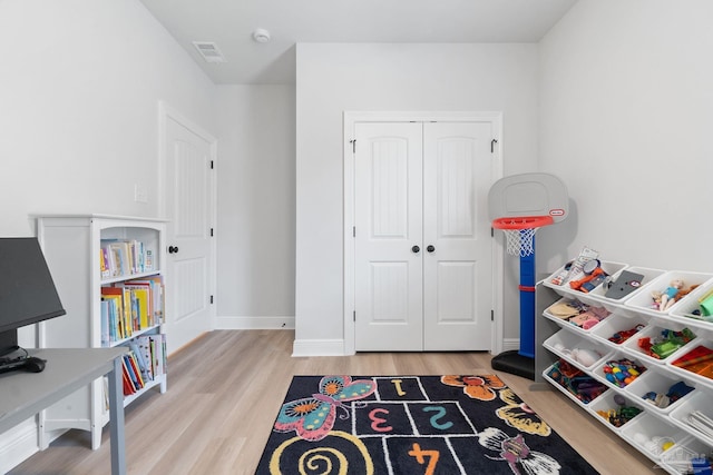 rec room featuring wood finished floors, visible vents, and baseboards