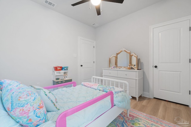 bedroom featuring ceiling fan, wood finished floors, and visible vents