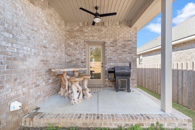 view of patio / terrace with area for grilling, fence, and a ceiling fan