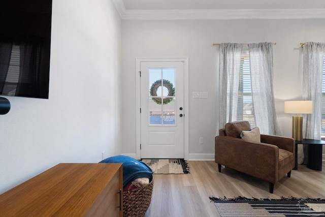 entrance foyer featuring baseboards, wood finished floors, and crown molding