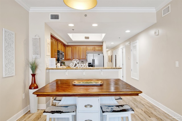 401 E Beach Blvd Unit 1207, Gulf Shores, AL 36542 - kitchen with appliances with stainless steel finishes, baseboards, light wood finished floors, ornamental molding, and a peninsula