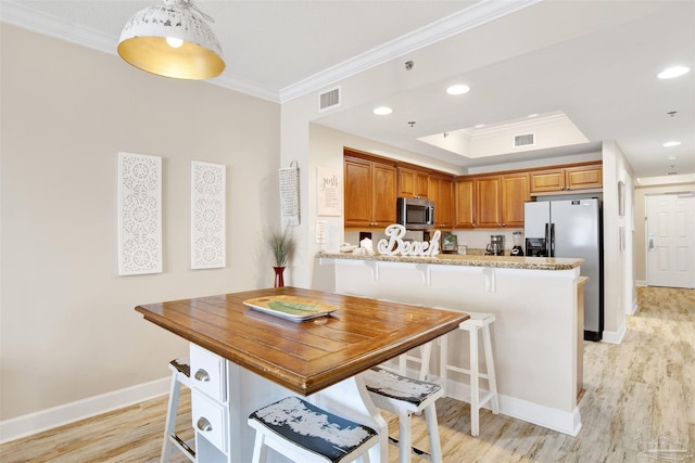 401 E Beach Blvd Unit 1207, Gulf Shores, AL 36542 - kitchen featuring appliances with stainless steel finishes, ornamental molding, a kitchen bar, light wood-style flooring, and baseboards
