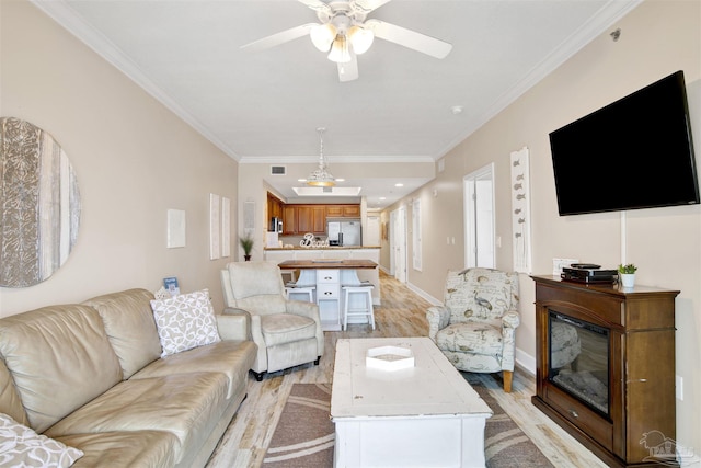 401 E Beach Blvd Unit 1207, Gulf Shores, AL 36542 - living room with light wood finished floors, a ceiling fan, crown molding, and baseboards