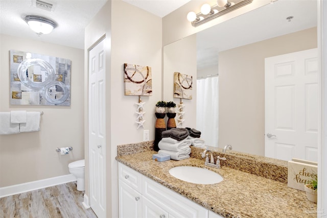 401 E Beach Blvd Unit 1207, Gulf Shores, AL 36542 - bathroom featuring vanity, toilet, wood finished floors, and baseboards