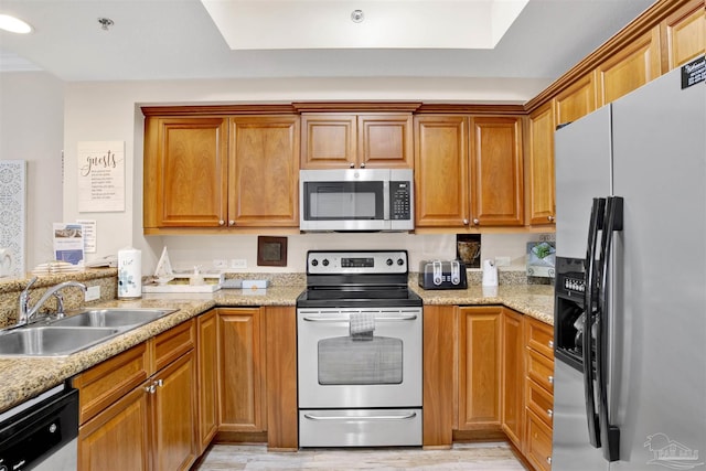 401 E Beach Blvd Unit 1207, Gulf Shores, AL 36542 - kitchen featuring appliances with stainless steel finishes, a sink, light wood finished floors, and brown cabinetry