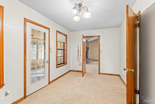 hallway featuring light carpet and a textured ceiling