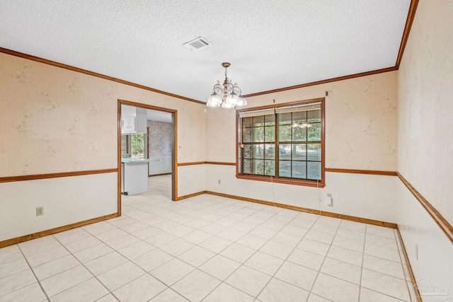 spare room with light tile patterned floors, a textured ceiling, ornamental molding, and a chandelier