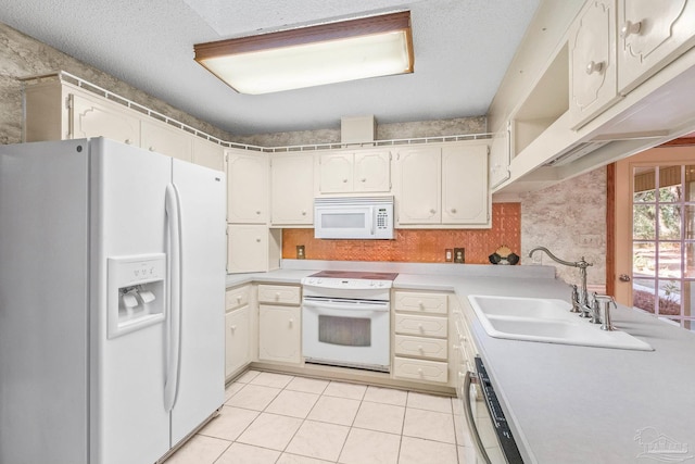 kitchen featuring light tile patterned flooring, white appliances, sink, and a textured ceiling