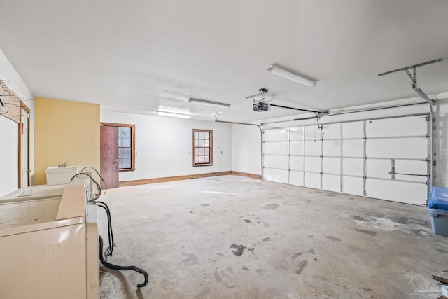 garage featuring a garage door opener and washer / dryer