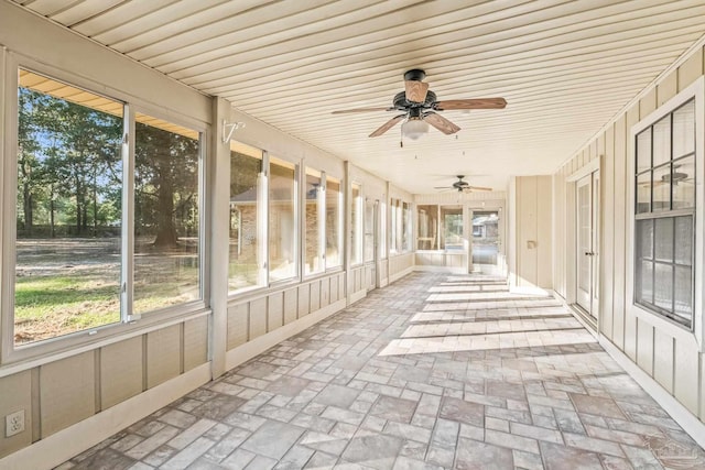 unfurnished sunroom featuring ceiling fan