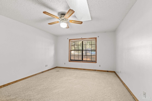 carpeted empty room with ceiling fan and a textured ceiling