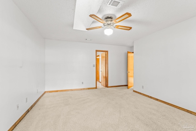 carpeted spare room with ceiling fan and a textured ceiling