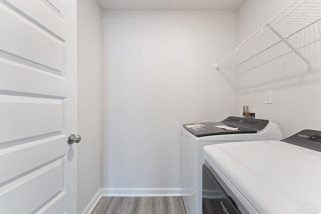 laundry area featuring hardwood / wood-style floors and separate washer and dryer