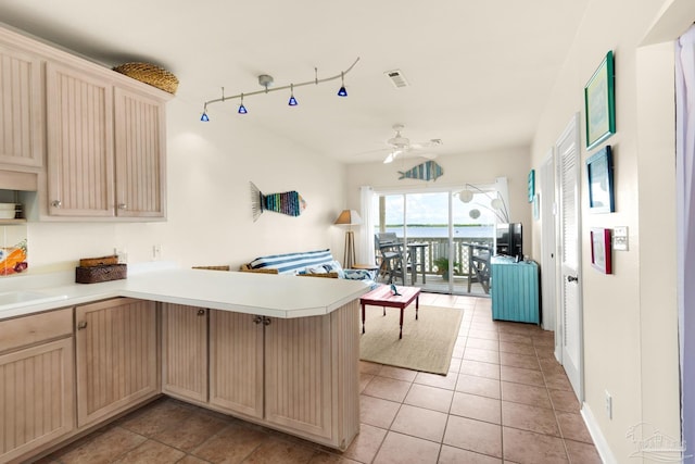 kitchen featuring ceiling fan, light tile patterned flooring, light brown cabinets, sink, and kitchen peninsula