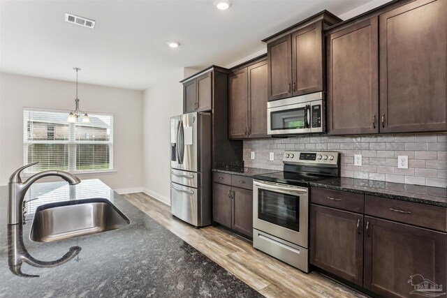 415 Broadleaf Cir, Cantonment, FL 32533 - kitchen with appliances with stainless steel finishes, light wood-type flooring, dark brown cabinets, decorative backsplash, and a sink