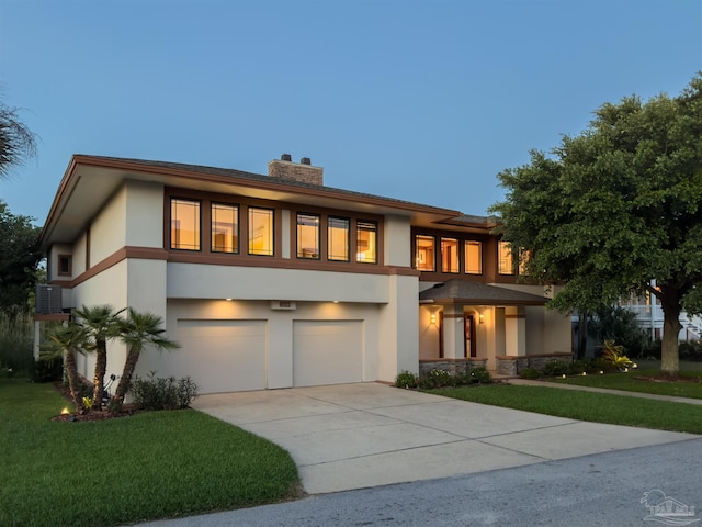 view of front of property with central AC unit, a front yard, and a garage