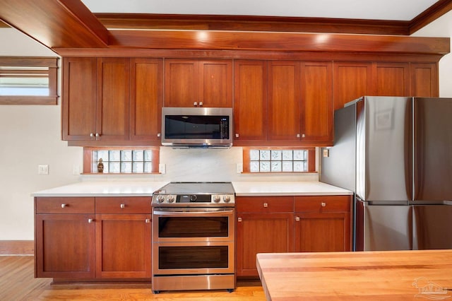 kitchen featuring stainless steel appliances, light hardwood / wood-style floors, and decorative backsplash