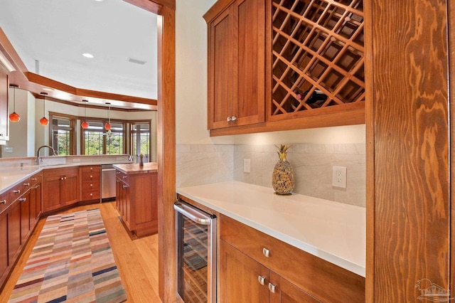 kitchen with light hardwood / wood-style floors, wine cooler, dishwasher, decorative light fixtures, and sink