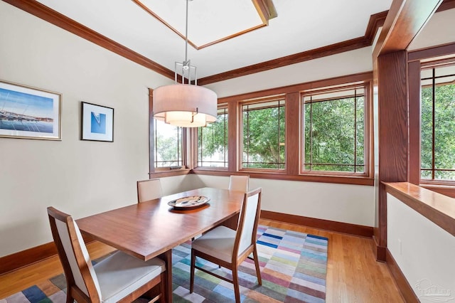 dining space featuring light wood-type flooring, plenty of natural light, and crown molding