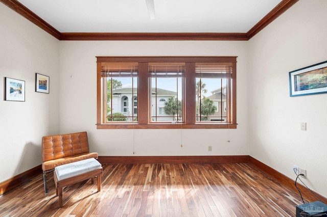 sitting room featuring dark hardwood / wood-style floors, ornamental molding, and a healthy amount of sunlight