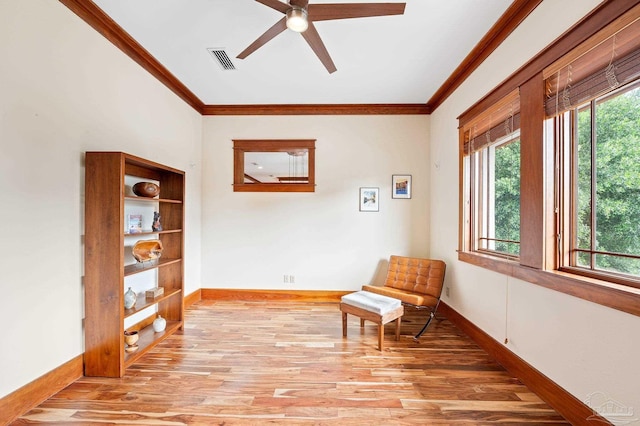 living area featuring ornamental molding, ceiling fan, and light hardwood / wood-style flooring