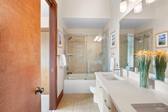 full bathroom featuring tile patterned flooring, bath / shower combo with glass door, toilet, and vanity