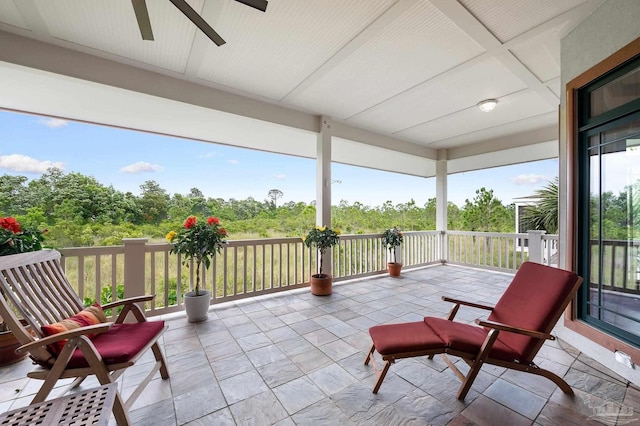 view of patio with ceiling fan and a balcony