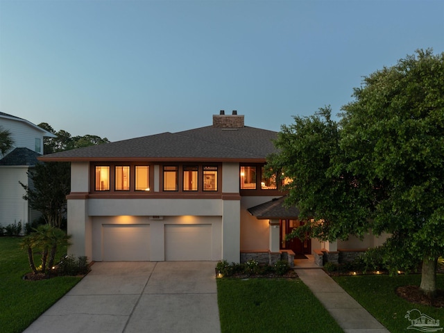 view of front of home featuring a lawn and a garage